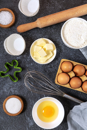 bakery background. Bake ingredient for recipe Easter cake or dessert, pie. Egg and flour, butter and kitchen textile black stone table. Top view, copy space.の写真素材