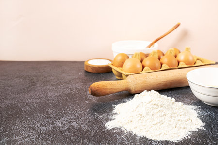 bakery background. Bake ingredient for recipe Easter cake or dessert, pie. Egg and flour, butter and kitchen textile black stone table. Top view, copy space.の写真素材