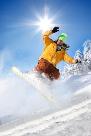 Snowboarder jumping against blue sky の写真素材