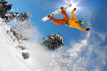 Snowboarder jumping against blue skyの写真素材