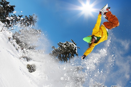 Snowboarder jumping against blue skyの写真素材