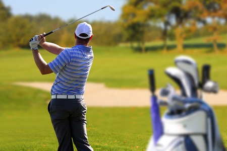 Man playing golf with golf bagの写真素材