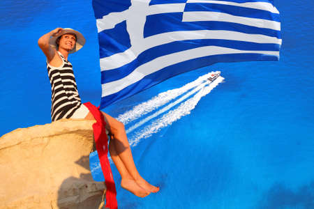 Summer paradise with sexy woman on cliff above sea in Greeceの写真素材