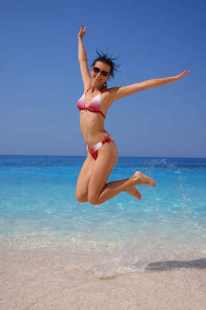 Happy Girl jumping on the beach の写真素材
