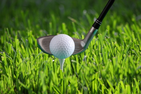 Golf ball on tee against fresh grassの写真素材