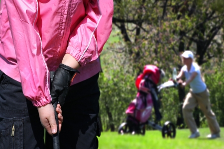little girl playing golfの写真素材