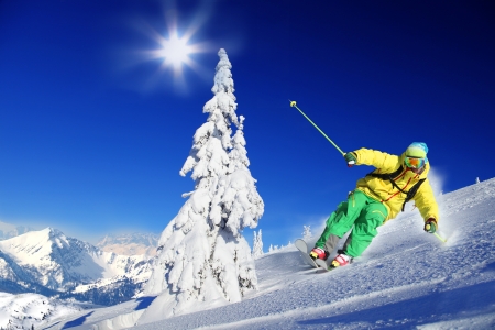 Skier skiing downhill in high mountainsの写真素材