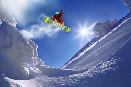 Snowboarder jumping against blue sky Snowboarder jumping against blue sky