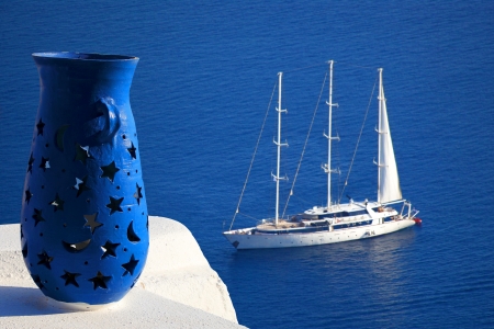 Santorini with blue Vase against sailboat in Greeceの写真素材