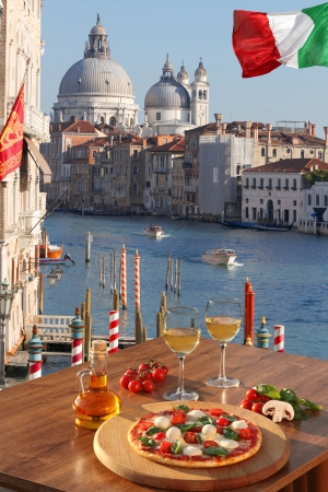 Classic Italian pizza and glases of wine  in Venice against Grand canal with boats, Italyの写真素材