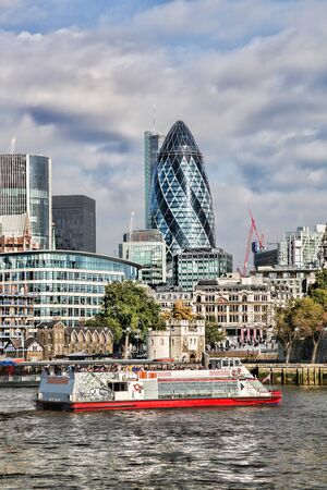 Modern London cityscape with boat, London, UKの写真素材