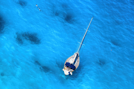 White Luxury Yacht against azure sea with swimming peopleの写真素材