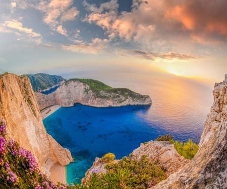 Navagio beach with shipwreck and flowers against sunset on Zakynthos island in Greeceの写真素材