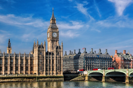 Big Ben with three double deckers buses on the bridge in London, Englandの写真素材