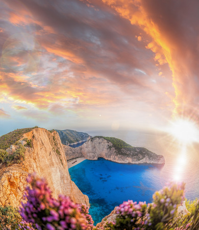 Navagio beach with shipwreck and flowers against sunset on Zakynthos island in Greeceの写真素材