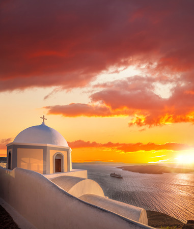 Old Town of Thira on the island Santorini, white church against colorful sunset in Greeceの写真素材