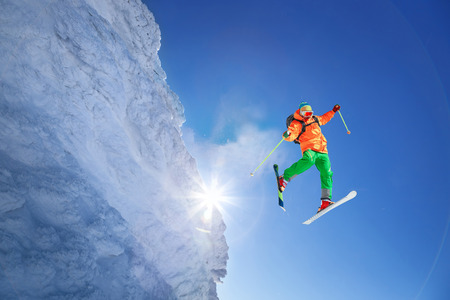 Skier jumping against blue sky from the rockの写真素材