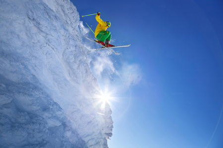 Skier jumping against blue sky from the rockの写真素材