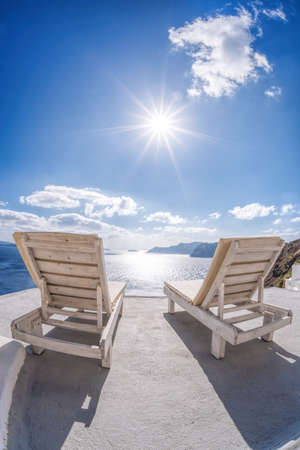 Relaxation on sunbeds against sunset in Oia village, Santorini island, Greeceの写真素材