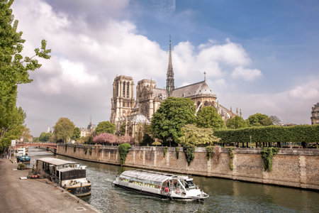 Paris, Notre Dame cathedral with tourboat on Seine river in Franceのeditorial素材