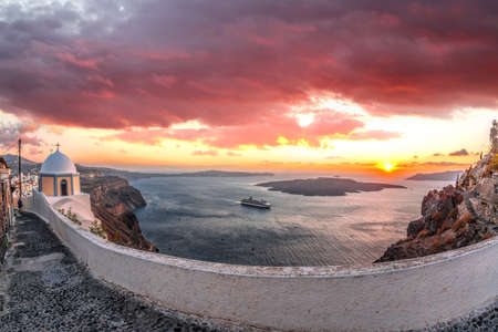 Old Town Thira on the Santorini island, famous churches against caldera with sunset over sea in Greece.の写真素材