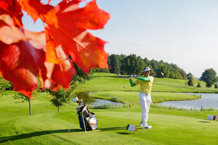 Man playing golf during colorful autumnの写真素材