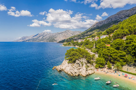 Aerial view of Punta Rata beach with boats and azure sea in Brela, Croatia, Dalmatia, Croatian azure...