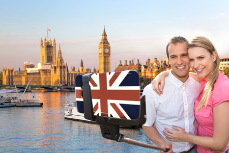 Couple in love taking a selfie portrait in front of Big Ben on their way around Westminster in London, Englandの写真素材