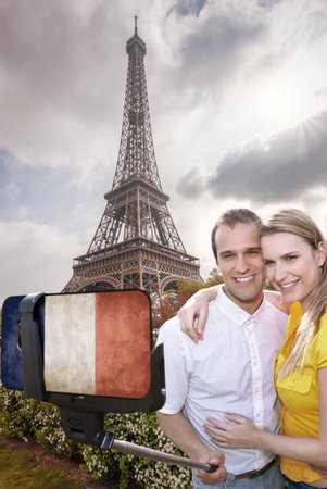 Happy couple of tourists taking selfie photo with cellphone covered a French flag in front of Eiffel Tower in Paris, Franceの写真素材