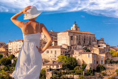 Woman in summer dress on vacation looking at the village of Gordes in Luberon, Provence, Franceの写真素材