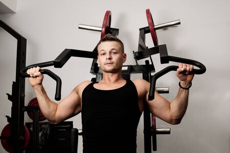 Man doing fitness training on machine with weights in a gym