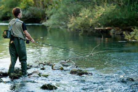 A fisherman fishing on a riverの写真素材