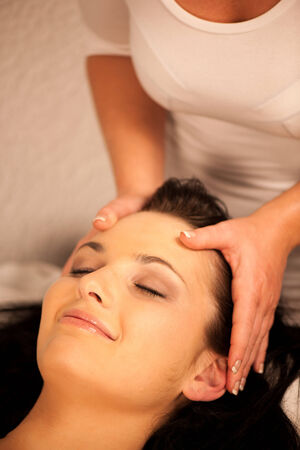 Woman having face massage treatment in wellness centerの写真素材