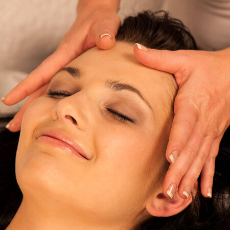 Woman having face massage treatment in wellness centerの写真素材
