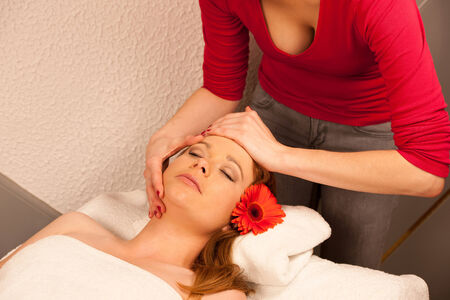 Woman having face massage treatment in wellness centerの写真素材