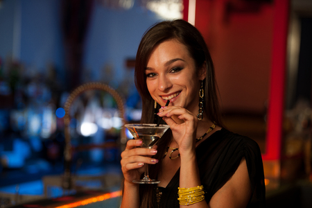 Girl drinks a cocktail in night clubの写真素材