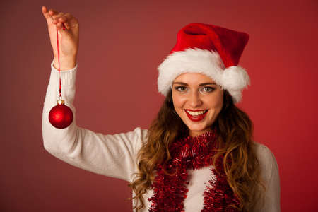 Pretty asian caucasian woman with santa claus hat celebrating christmass isolated over white backgroundの写真素材