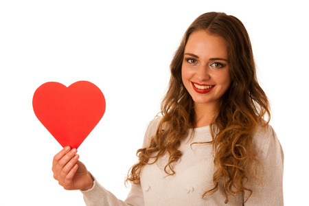attractive asian caucasian woman holding red heart in her hands for valenitine's day isolatedの写真素材