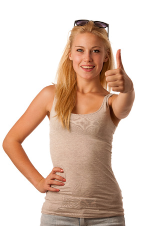 Attractive blonde woman with sunglasses in her hair gesturing ok sign with showing thumb up isolated over whiteの写真素材