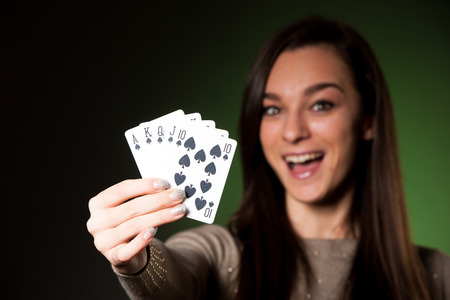Beautiful caucasian woman with poker cards gambling in casino