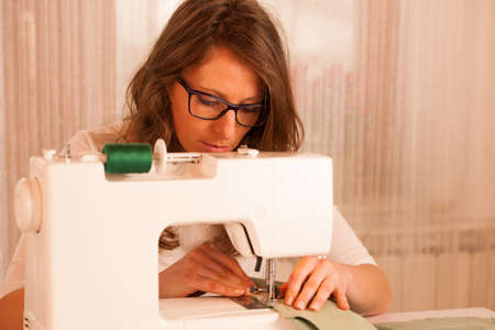 beautiful Dressmaker woman working with sewing machine