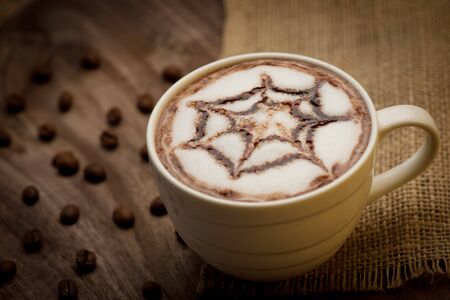 Cup of cappuccino served on wooden table with coffee beans in the background4の写真素材