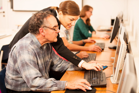 Group of adults learning computer skills. Intergenerational transfer of knowledge.