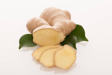 Ginger root with green leaves isolated over white.
