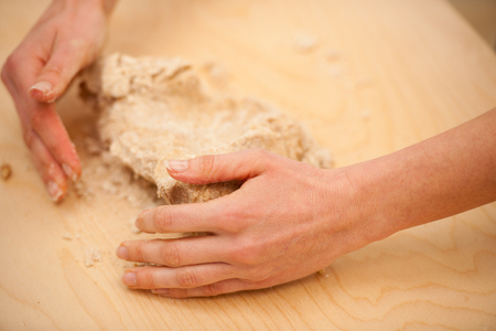 Kneading dough, preparing homemade bread out of spelt flour on wooden table.の写真素材