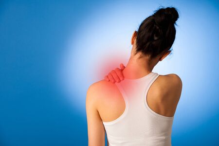 Waman having pain in her neck over blue background