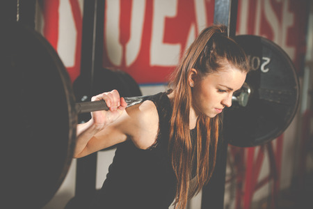 Woman workout in fitness gym with barbells - powerlift workoutの写真素材