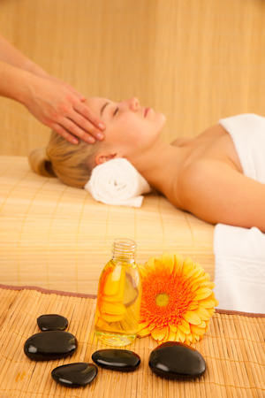 Beautiful blonde woman enyoing massage treatment in sap salonの写真素材