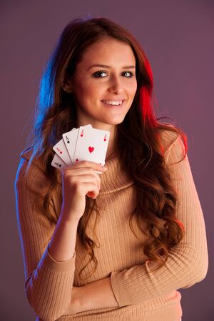 Beautiful brunette holding four aces as a sign for poker game, gambling and casino