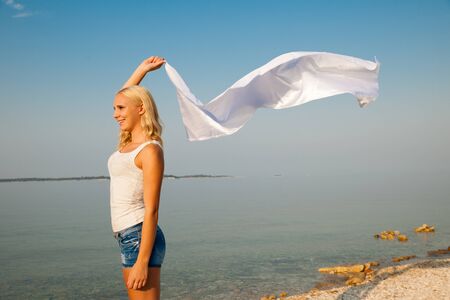 Beautiful Girl With White fabric on The Beach. Travel and Vacation. Freedom Concept.の写真素材